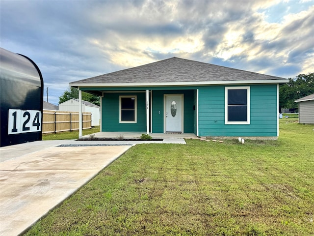124 Oakwood St, Chico, TX 76431 - view of front of home featuring a front lawn, roof with shingles, covered porch, and fence