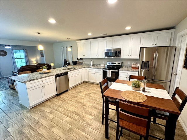 124 Oakwood St, Chico, TX 76431 - kitchen featuring a peninsula, white cabinetry, appliances with stainless steel finishes, and recessed lighting