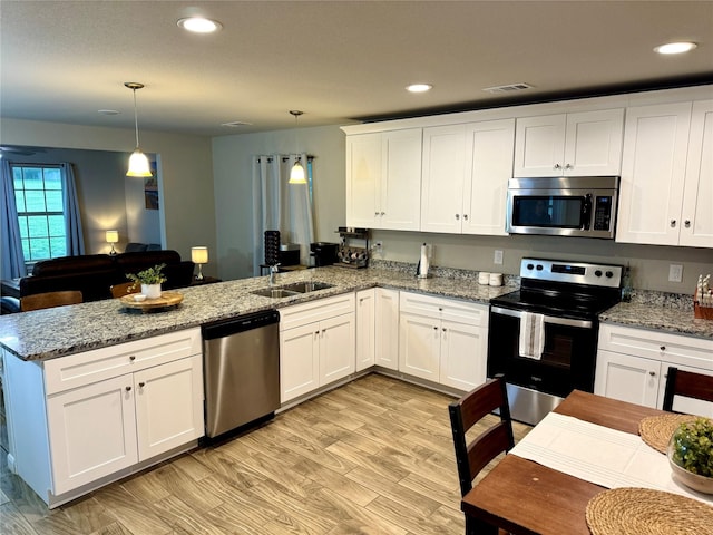 124 Oakwood St, Chico, TX 76431 - kitchen featuring visible vents, a sink, a peninsula, white cabinets, and appliances with stainless steel finishes