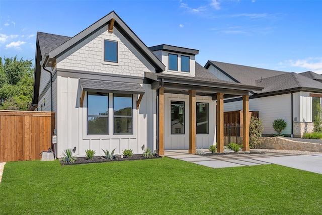 view of front of home featuring fence, a front yard, and board and batten siding