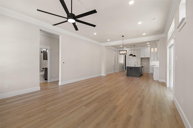 unfurnished living room featuring light wood-style flooring, a ceiling fan, ornamental molding, and recessed lighting