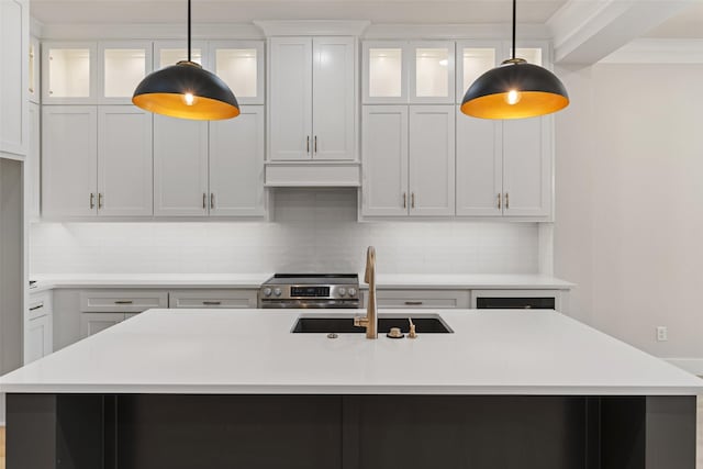 kitchen featuring light countertops, decorative backsplash, stainless steel electric stove, and a sink