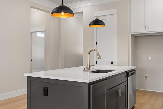 kitchen with light wood finished floors, dishwasher, ornamental molding, and a sink