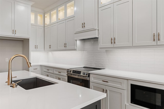 kitchen featuring a sink, white cabinetry, black microwave, light countertops, and electric stove