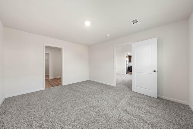 spare room with light colored carpet and baseboards