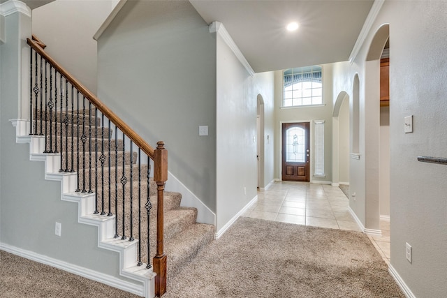 14629 Gilley Ln, Fort Worth, TX 76052 - foyer featuring light tile patterned floors, baseboards, arched walkways, light colored carpet, and stairs