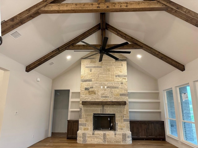 1099 Silver Sage Trl, Weatherford, TX 76085 - unfurnished living room with wood finished floors, beam ceiling, high vaulted ceiling, a ceiling fan, and a stone fireplace