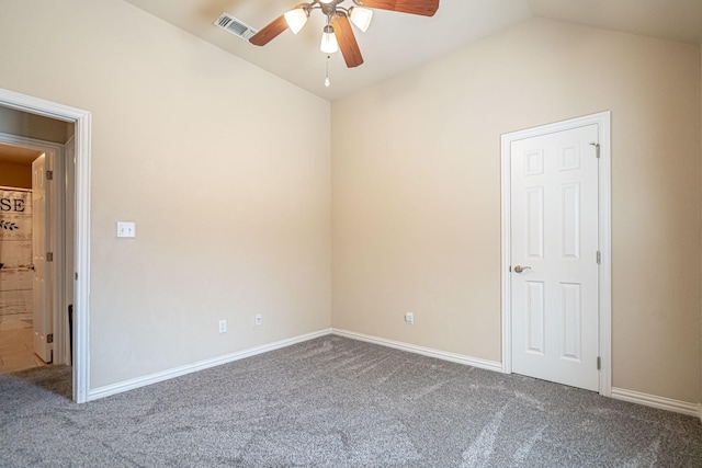unfurnished room featuring visible vents, vaulted ceiling, ceiling fan, carpet flooring, and baseboards