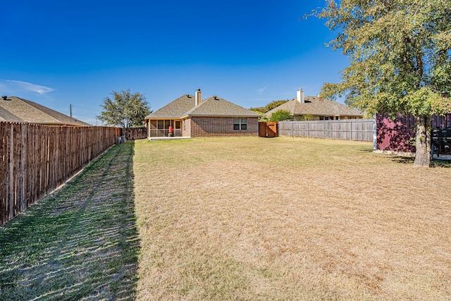 view of yard with a sunroom and a fenced backyard