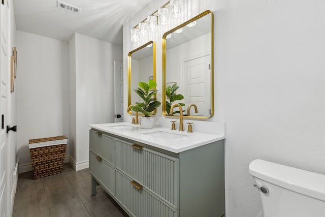 6200 Ravenswood Dr, Fort Worth, TX 76112 - bathroom featuring toilet, double vanity, and baseboards