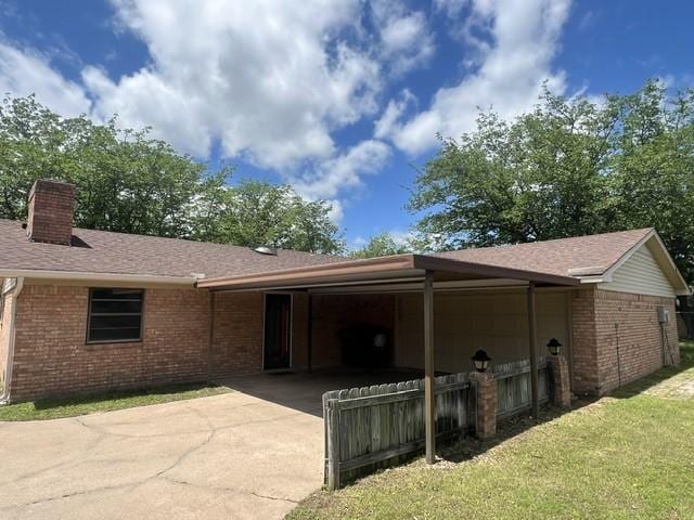 3209 Mimosa Dr, Sherman, TX 75092 - view of home's exterior with brick siding, concrete driveway, a chimney, and a lawn