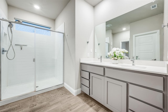 2100 Blackcap St, Denton, TX 76205 - full bathroom with visible vents, a sink, a shower stall, double vanity, and wood finished floors