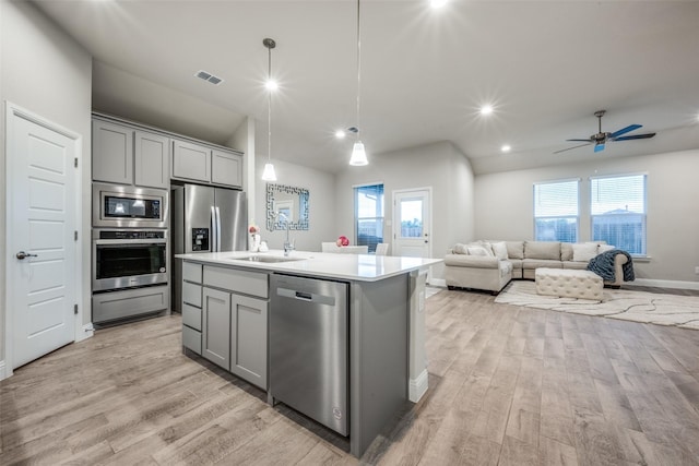 2100 Blackcap St, Denton, TX 76205 - kitchen featuring a sink, stainless steel appliances, visible vents, light wood finished floors, and gray cabinetry