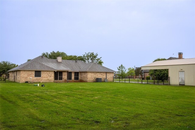 10020 Richard Cir, Forney, TX 75126 - back of house featuring cooling unit, a chimney, and a lawn