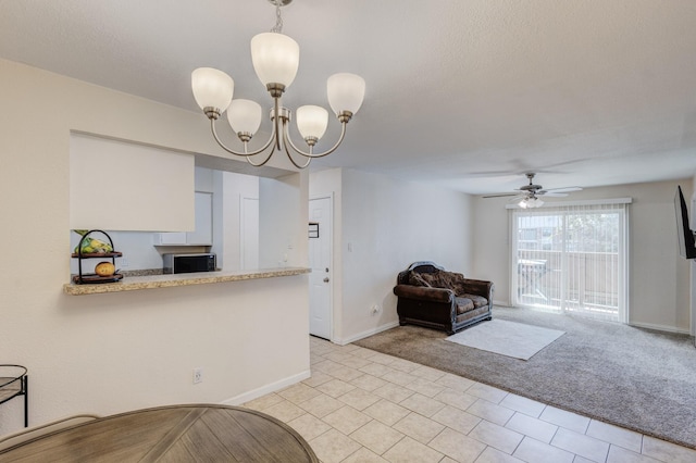 interior space featuring pendant lighting, light carpet, light countertops, and baseboards