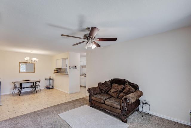 living room with light tile patterned floors, light carpet, baseboards, and ceiling fan with notable chandelier
