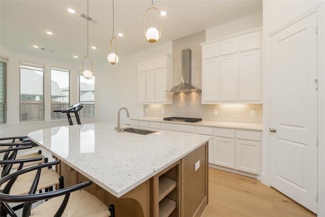 9415 Royal Forest Dr, Oak Point, TX 75068 - kitchen with wall chimney range hood, a sink, gas cooktop, light wood-style flooring, and decorative backsplash
