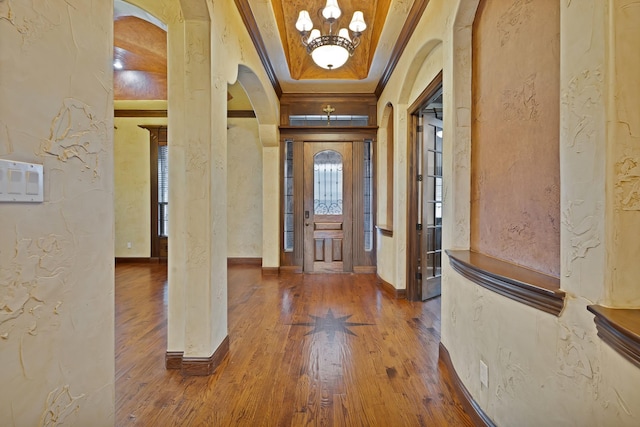 1206 Genesis Dr, Mansfield, TX 76063 - entrance foyer with a tray ceiling, an inviting chandelier, crown molding, wood finished floors, and arched walkways