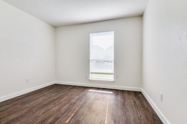 2210 Sheriff Dr, Grand Prairie, TX 75051 - unfurnished room featuring healthy amount of natural light, dark wood-style flooring, and baseboards