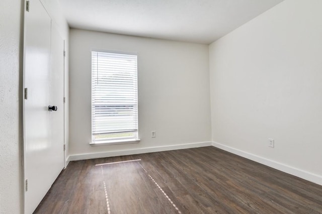 2210 Sheriff Dr, Grand Prairie, TX 75051 - spare room featuring dark wood-style floors, healthy amount of natural light, and baseboards