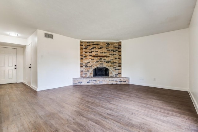 2210 Sheriff Dr, Grand Prairie, TX 75051 - unfurnished living room with wood finished floors, baseboards, and a brick fireplace
