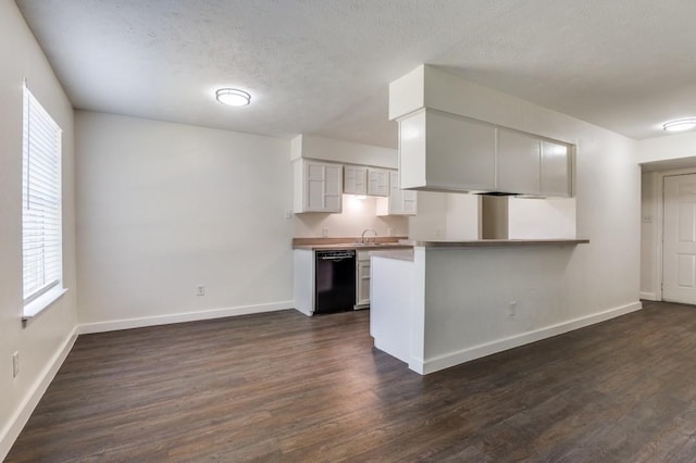 2210 Sheriff Dr, Grand Prairie, TX 75051 - kitchen with black dishwasher, baseboards, dark wood finished floors, a peninsula, and a textured ceiling