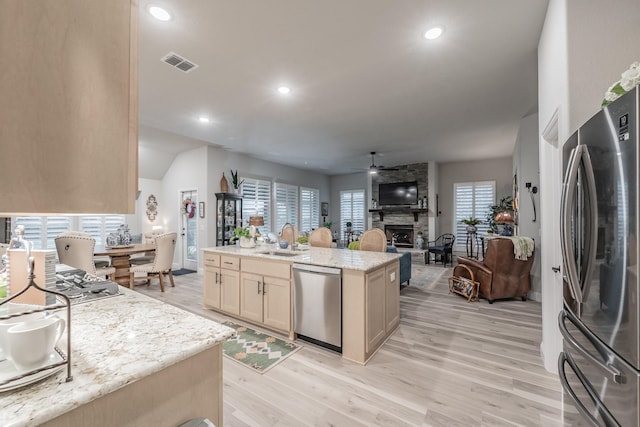 1076 Fleetwood Dr, Justin, TX 76247 - kitchen featuring appliances with stainless steel finishes, a sink, light wood-style floors, recessed lighting, and an island with sink