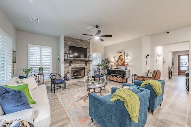 1076 Fleetwood Dr, Justin, TX 76247 - living room featuring a ceiling fan, plenty of natural light, wood finished floors, and a stone fireplace
