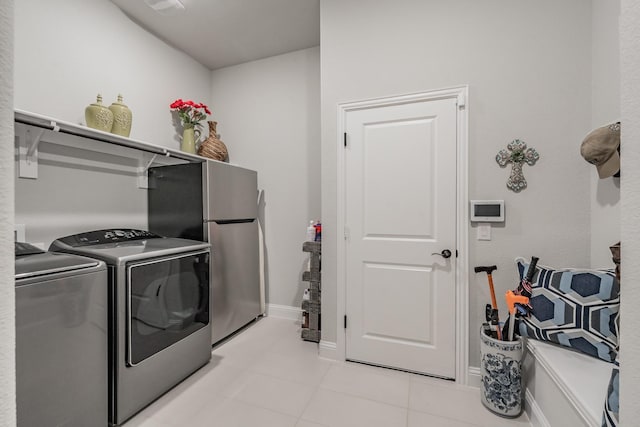 1076 Fleetwood Dr, Justin, TX 76247 - laundry area featuring washer and dryer, baseboards, and light tile patterned floors