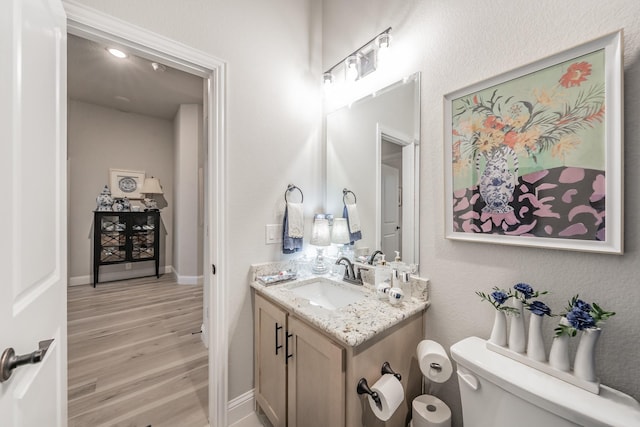 1076 Fleetwood Dr, Justin, TX 76247 - bathroom featuring wood finished floors, toilet, vanity, and baseboards