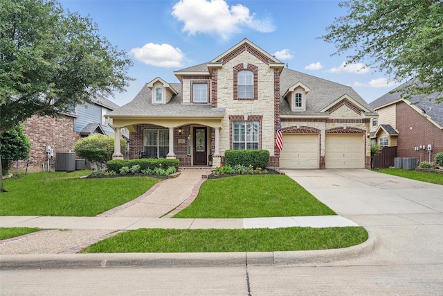 209 Odyssey Ln, Mansfield, TX 76063 - view of front facade featuring a front lawn, concrete driveway, central AC unit, and stone siding