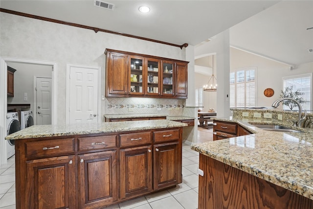 209 Odyssey Ln, Mansfield, TX 76063 - kitchen featuring a sink, independent washer and dryer, light tile patterned flooring, visible vents, and backsplash