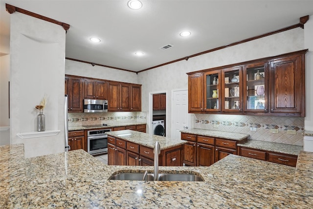 209 Odyssey Ln, Mansfield, TX 76063 - kitchen with a sink, stainless steel appliances, visible vents, washer / dryer, and light stone counters