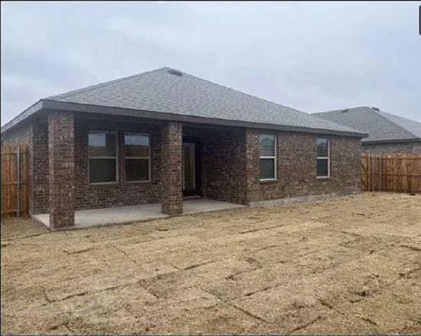 rear view of property with a patio, brick siding, and a fenced backyard
