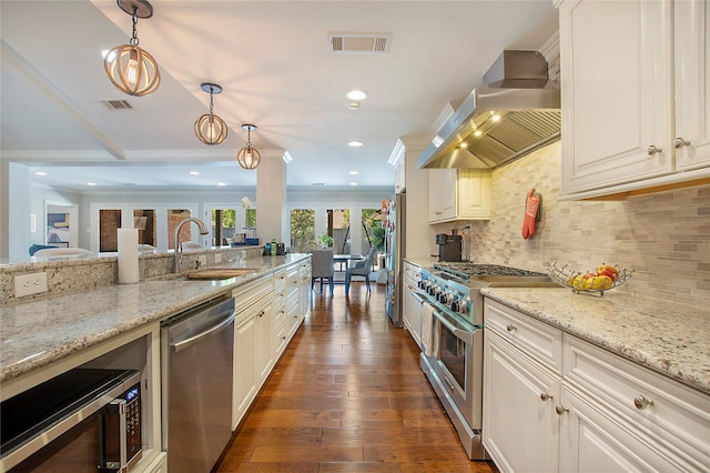 kitchen featuring appliances with stainless steel finishes, wall chimney exhaust hood, a sink, crown molding, and dark wood-style floors
