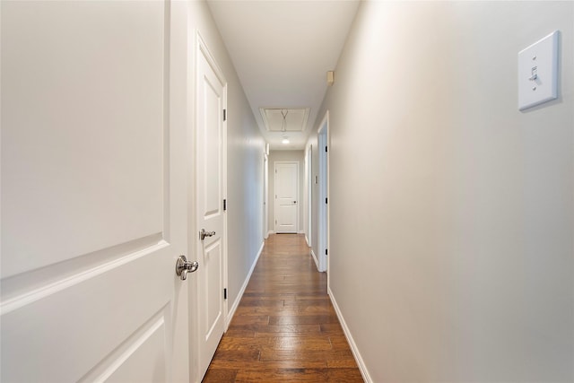 hall featuring attic access, dark wood finished floors, and baseboards