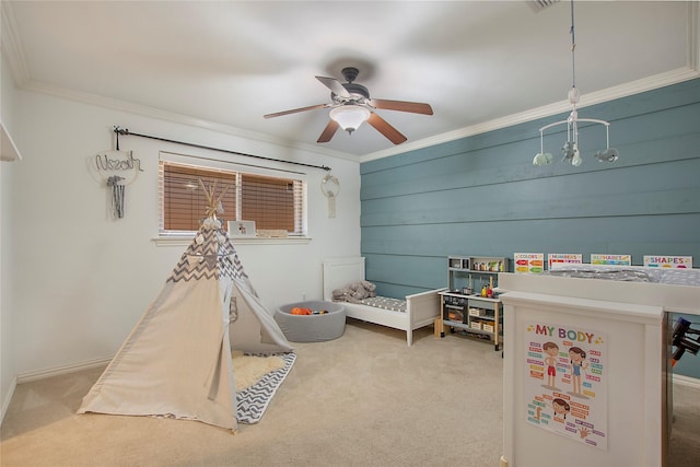 recreation room with carpet flooring, ornamental molding, and a ceiling fan