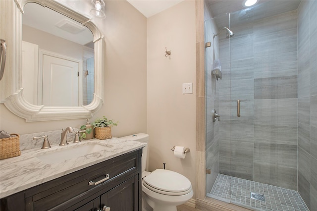 bathroom with a shower stall, toilet, and vanity