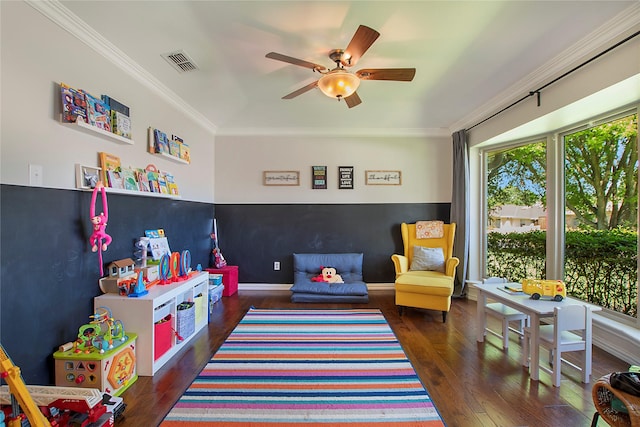 recreation room featuring hardwood / wood-style floors, ceiling fan, ornamental molding, and baseboards
