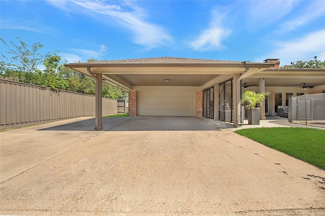 view of parking / parking lot featuring a carport, fence, concrete driveway, and an attached garage