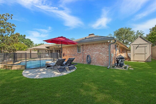 back of property featuring a storage unit, brick siding, a patio area, a chimney, and an outbuilding