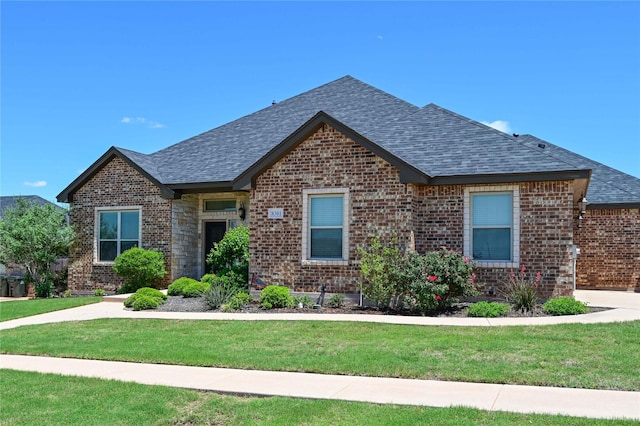8301 Cimarron Trl, Abilene, TX 79606 - view of front facade with a shingled roof, brick siding, and a front lawn
