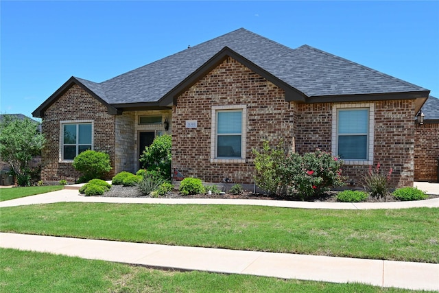 8301 Cimarron Trl, Abilene, TX 79606 - view of front of house featuring a shingled roof, a front lawn, and brick siding