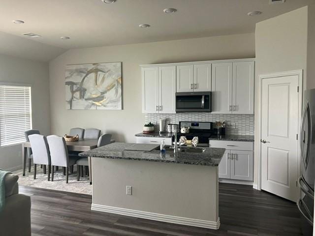 213 Irvin Dr, Royse City, TX 75189 - kitchen featuring appliances with stainless steel finishes, dark stone counters, tasteful backsplash, white cabinetry, and recessed lighting