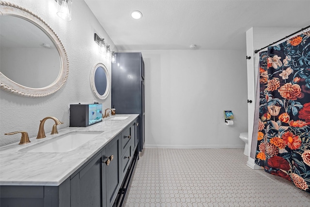 full bathroom featuring recessed lighting, double vanity, baseboards, and a sink
