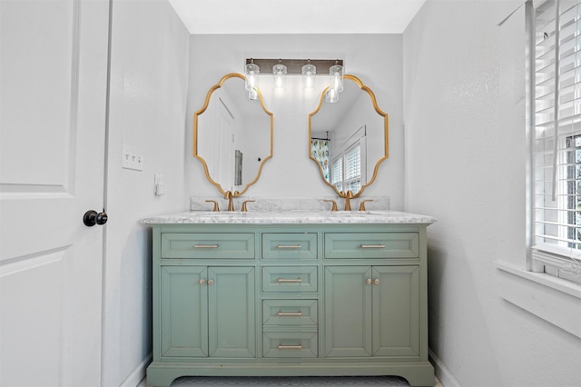 bathroom featuring baseboards, double vanity, and a sink