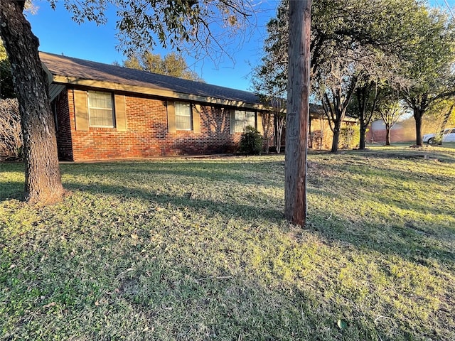 single story home featuring brick siding and a front yard