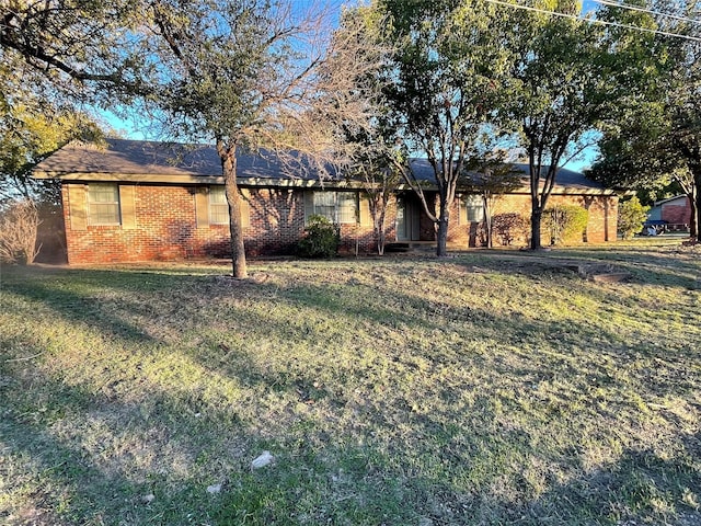 view of front of house with brick siding and a front lawn