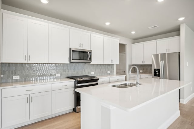604 Willet Dr, Mckinney, TX 75069 - kitchen with stainless steel appliances, a sink, light wood-style floors, white cabinets, and recessed lighting