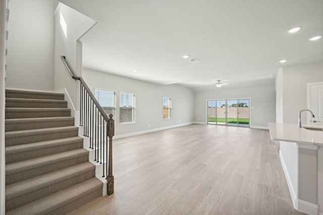 604 Willet Dr, Mckinney, TX 75069 - unfurnished living room with baseboards, light wood finished floors, ceiling fan, and a sink